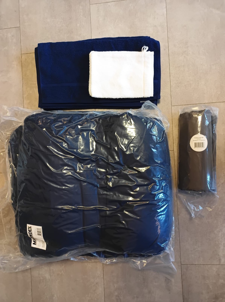 De inhoud van een linnenpakket: een dekbed, een dekbedovertrek, een handdoek en een washand.